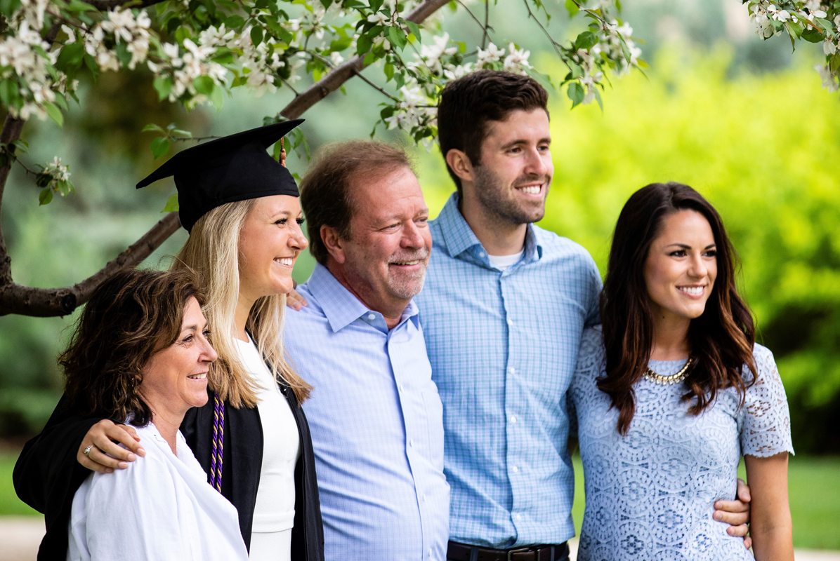 a family poses for a photo under a tree on the St. Paul campus